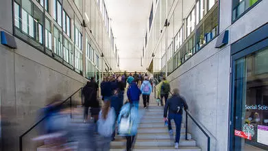 blurred image of a group of people walking up and down a flight of stairs
