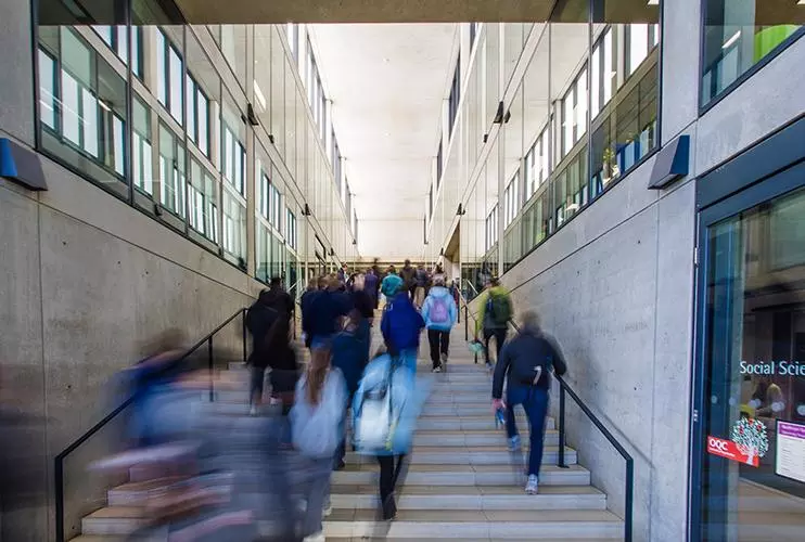 blurred image of a group of people walking up and down a flight of stairs
