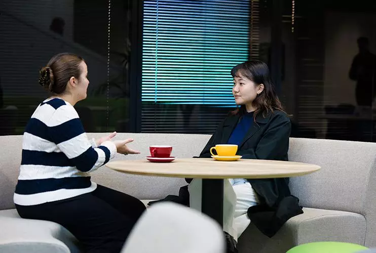 image of two students sat at a round table facing one another