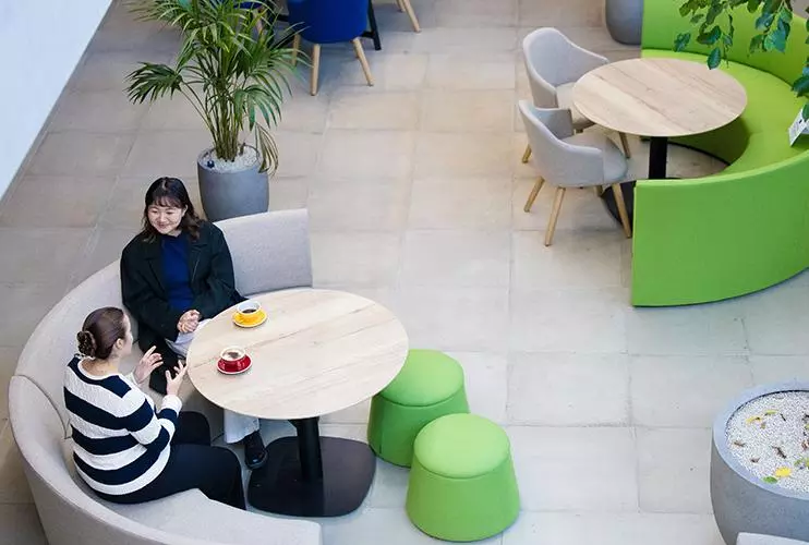 overhead view of two female students sat at a circular table talking